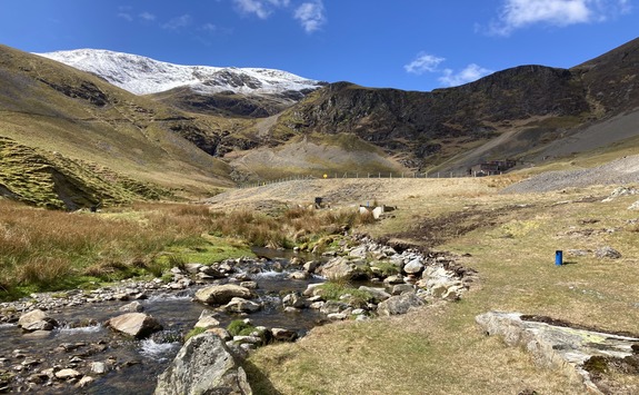 A stream with mountains in the background 